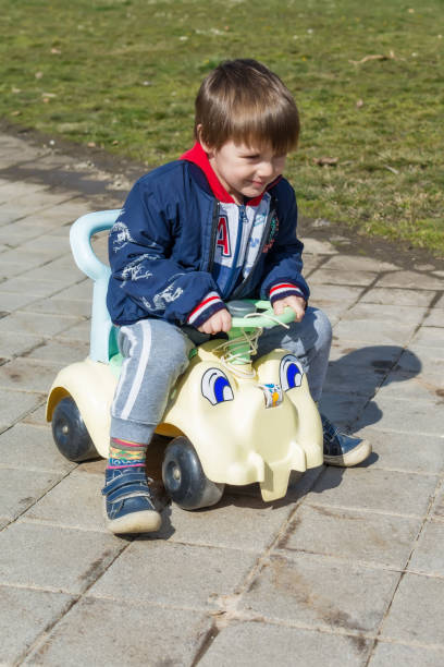istock A boy drives a children's car in the park 936638970