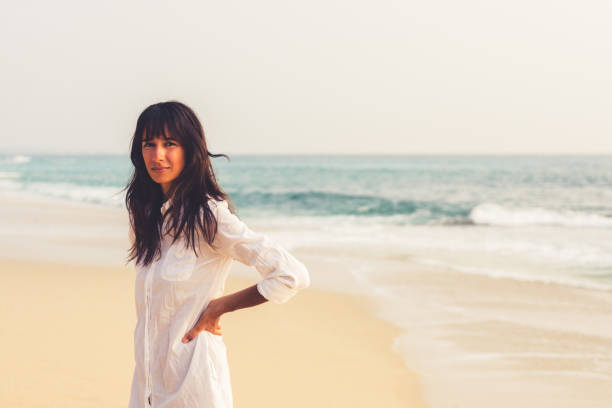 istock A young girl by the ocean on a bright summer day 936639148