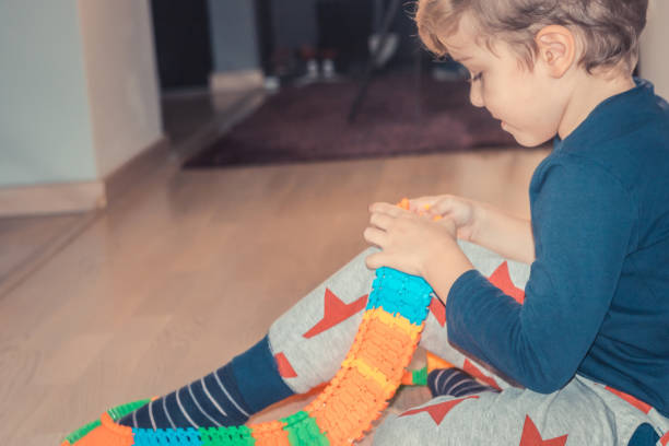 istock Little boy making car trail out of plastic blocks. 936641900