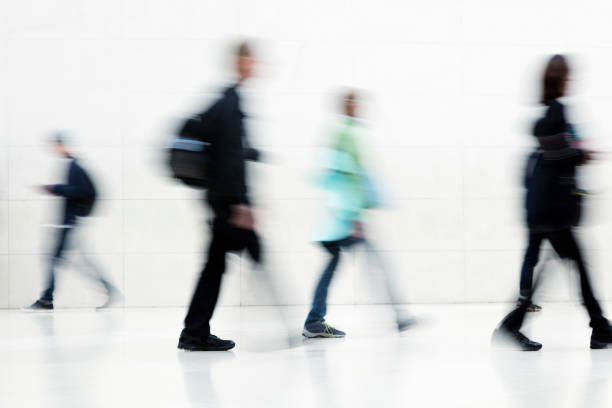 istock Group of Motion Blurred People Walking on White Background 936642654