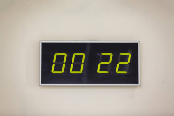 istock Black digital clock on a white background showing time  hours minutes 936645732