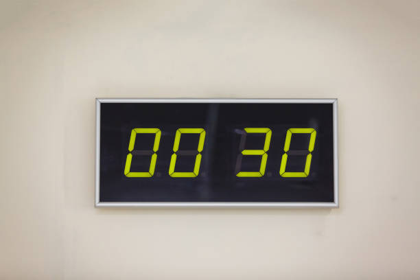 istock Black digital clock on a white background showing time 0 hours 30 minutes 936645758