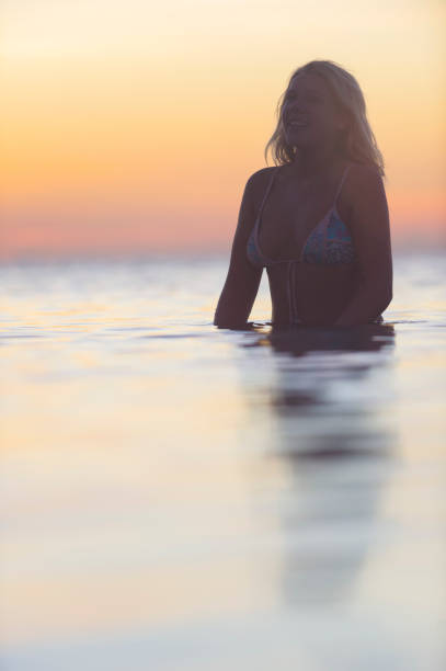 istock Woman swimming alone in the ocean at sunset. 936645948