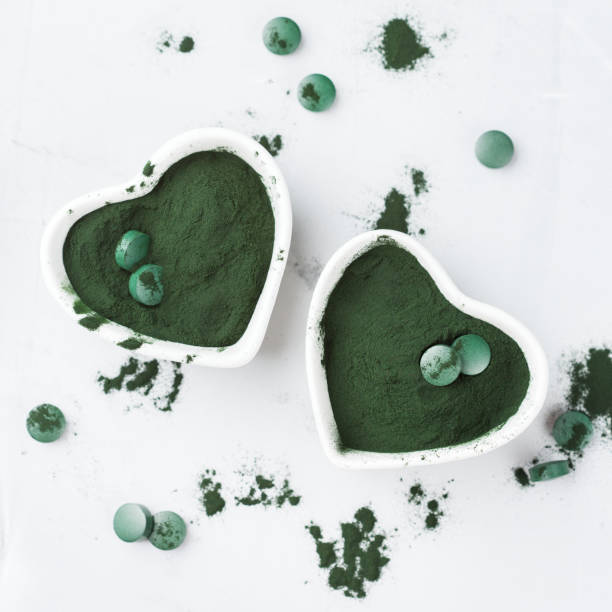 istock Superfood concept ground green spirulina algae powder, pills tablets 936647116