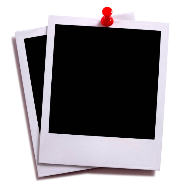 istock Two blank instant camera photo prints with red pushpin isolated on white with shadow. 936647574