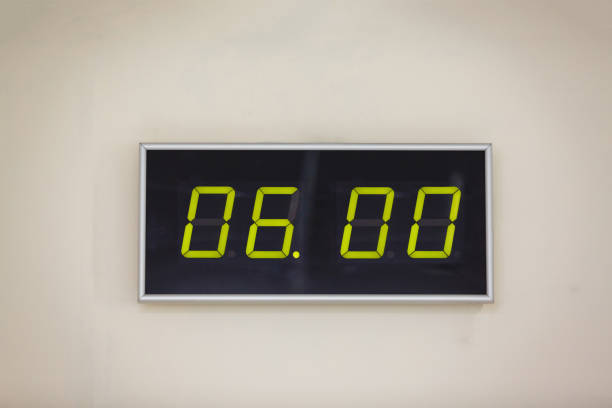 istock Black digital clock on a white background showing time six o'clock 936648478