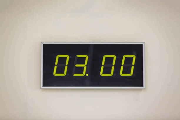 istock Black digital clock on a white background showing time three, night; lunch; 936649784