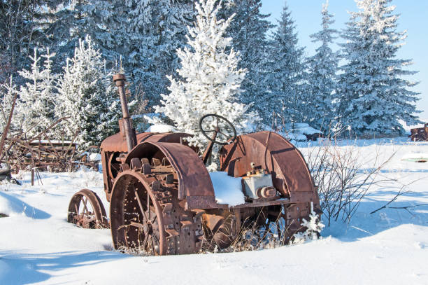 Old farmer's vehicle abandoned in snow- very old steel wheeled tractor in deep snow