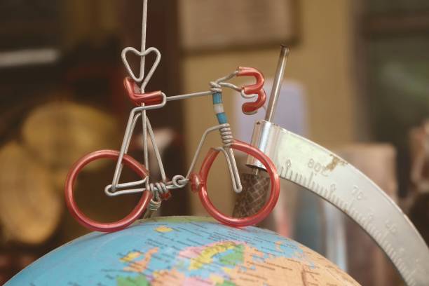 Miniature Bicycle Figure on Geography Globe or Planet Sphere Model, Cyling to Destination.
