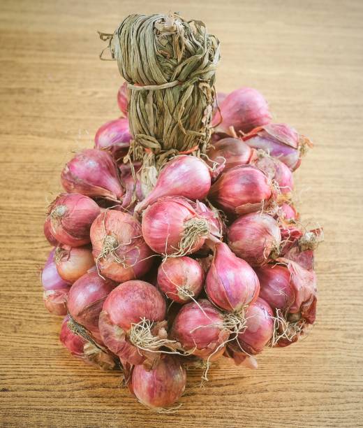 istock Bunch of Fresh Red Onions on Wooden Table 936658904