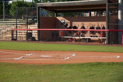 horizontal photograph of home plate on a baseball field with the dugout in the background