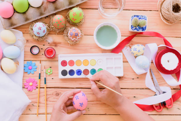 istock Happy easter! A woman hand painting Easter eggs. Happy family preparing for Easter. 936665032