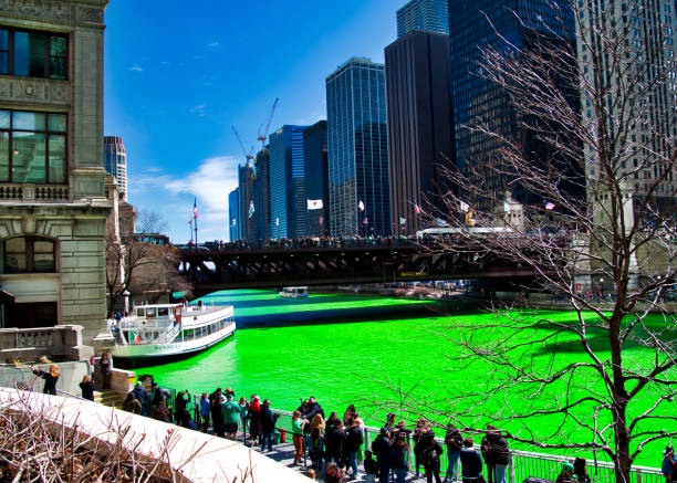 espectador ve el río chicago es teñido de verde para el día de san patricio. - american flag architectural feature architecture chicago fotografías e imágenes de stock