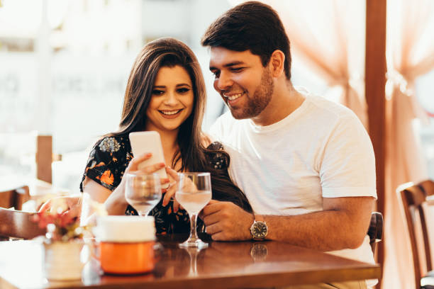 istock Couple at restaurant looking at his smart phone 936674414