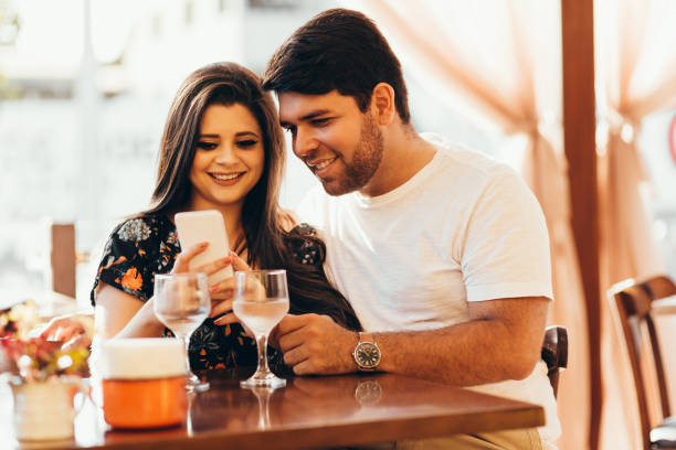 istock Couple at restaurant looking at his smart phone 936674418