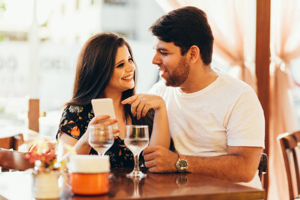 istock Couple at restaurant looking at his smart phone 936674440