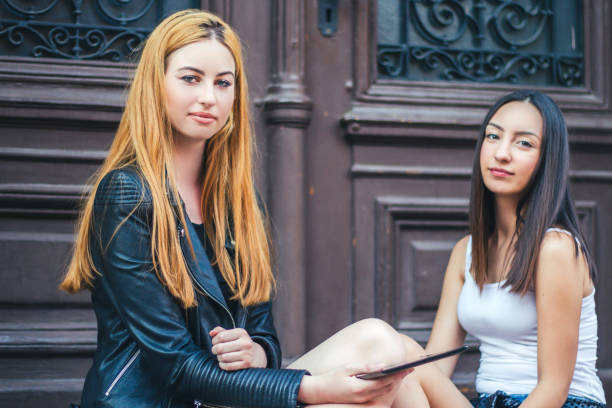 istock Two beautiful young woman with tablet. 936678072