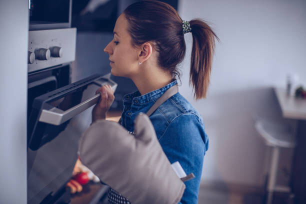 istock Woman checking food in the oven 936688712