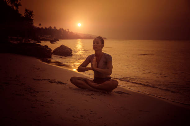 istock Woman practicing yoga on the beach 936689246