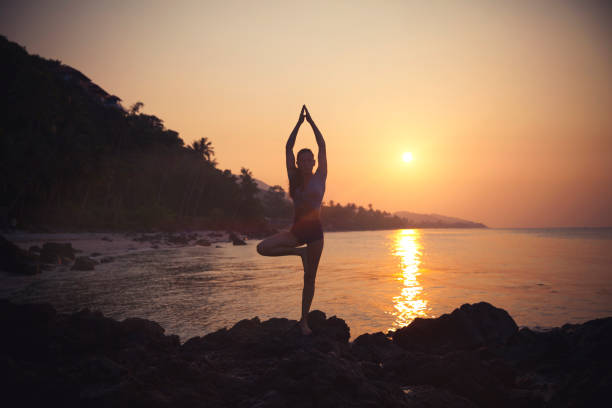 istock Woman practicing yoga on the beach 936689248