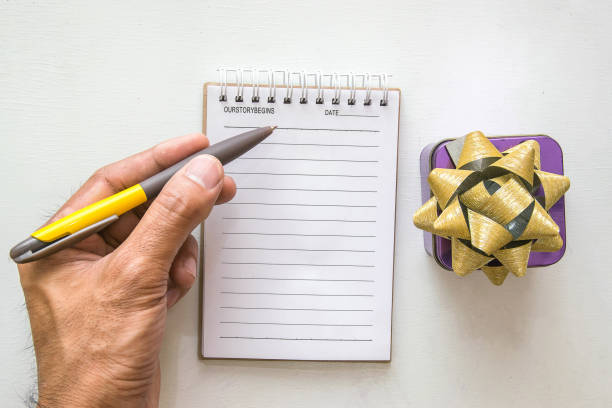 istock man writing notepad gift box and pencil on desk wood  background.using wallpaper for education, business photo.Take note of the product for book with paper and concept, object or copy space 936693772
