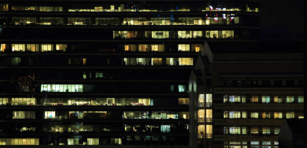 istock working overtime in modern glass wall coperate office. 936722676