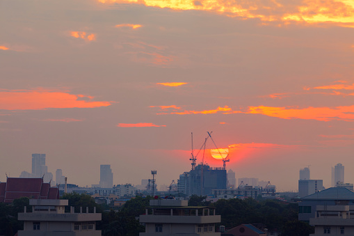 Aerial View Construction Cranes Silhouette over Construction Site on Amazing cityscape Sunset Sky Background in the Evening, Colorful sky and lighting, Building site construction, Technology Machine Equipment Transportation.