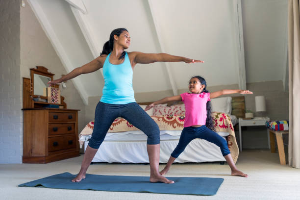 istock Mother and daughter practicing yoga in bedroom 936749852