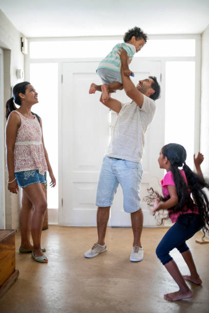 familia feliz está disfrutando en la sala de estar en casa - home interior arrival father family fotografías e imágenes de stock