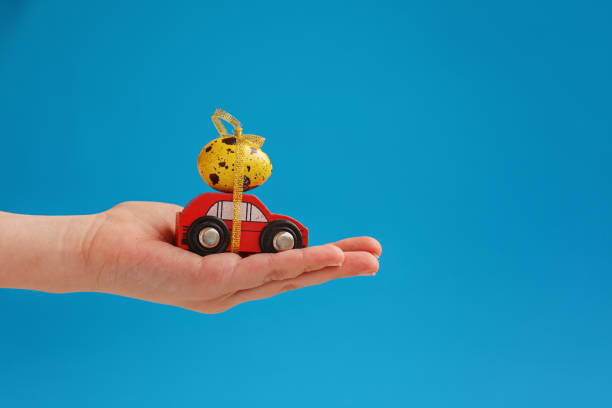 Child hands holding easter egg on car. Holiday concept stock photo