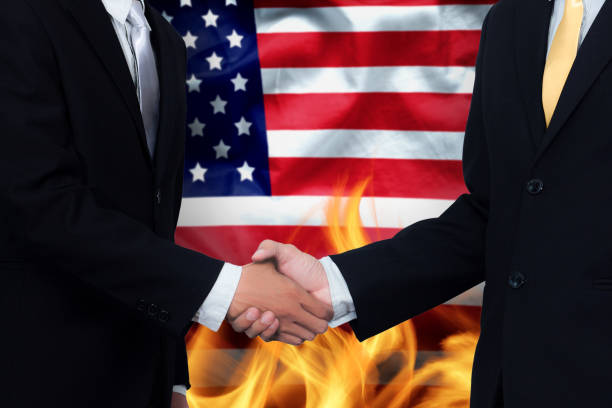 handelsabkommen und geschäftspraktiken in den vereinigten staaten-konzept. hand der geschäftsmann schütteln auf amerika flagge hintergrund und feuer - corrupt practice stock-fotos und bilder