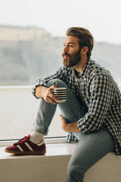 istock Serious man relaxing by the window during his coffee time. 936756556