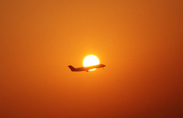 Airplane taking off against rising sun. Travel concept.