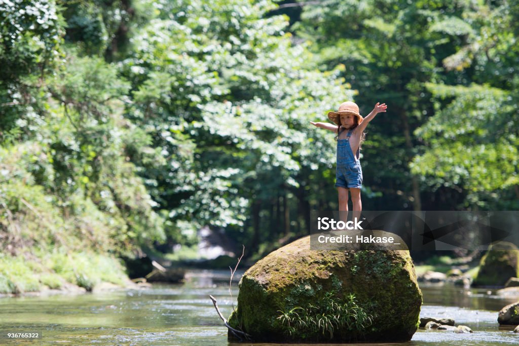 Little girl playing on a stream Child Stock Photo