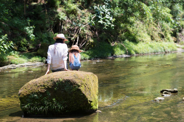 istock Mother and daughter playing in mountain stream 936765642