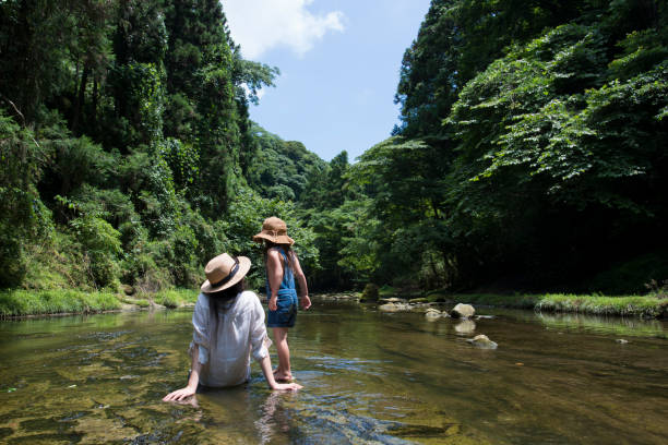 istock Mother and daughter playing in mountain stream 936765692