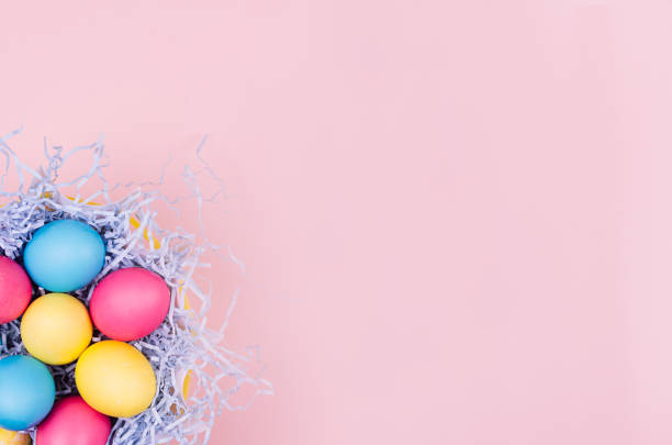 istock Easter colorful eggs in fun blue nest on soft pink background, copy space, top view. 936765988