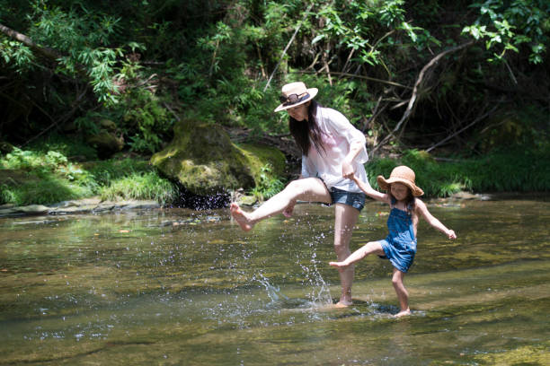 istock Mother and daughter playing in mountain stream 936768884