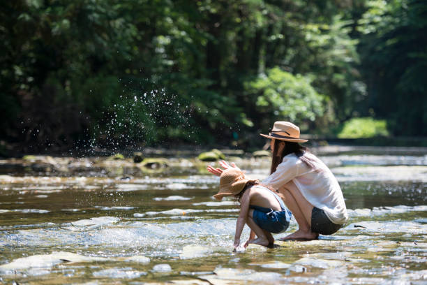 Mother and daughter playing in mountain stream