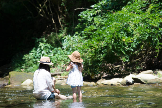 istock Mother and daughter playing in mountain stream 936770130