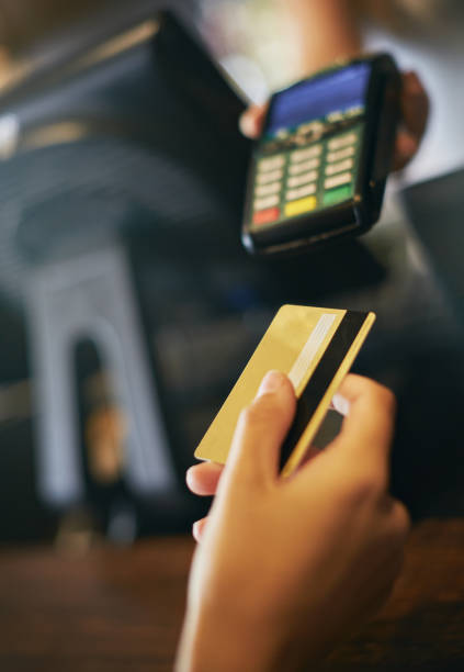 istock Hand holds card towards mobile credit card machine 936770180