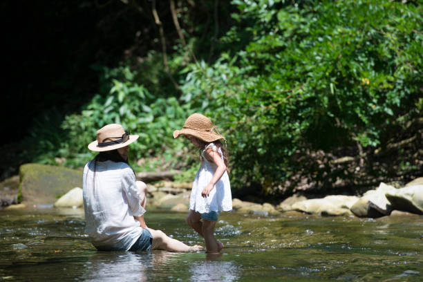 istock Mother and daughter playing in mountain stream 936770494