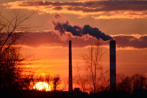 istock Chimneys and smoke against the setting sun. 936771002