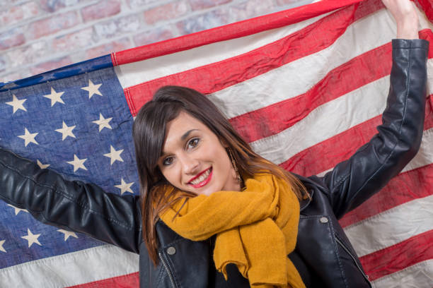 istock young brunette in front of an  american flag 936776916