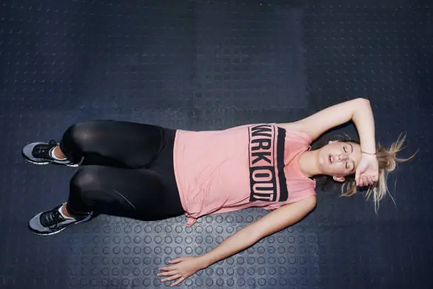 High angle shot of an attractive young woman taking a break after working out at the gym