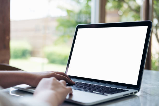 istock Mockup image of hand using laptop with blank white screen on vintage wooden table in cafe 936793192