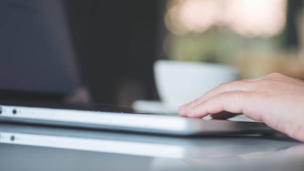 istock Closeup image of hands working and typing on laptop keyboard on glass table 936793358