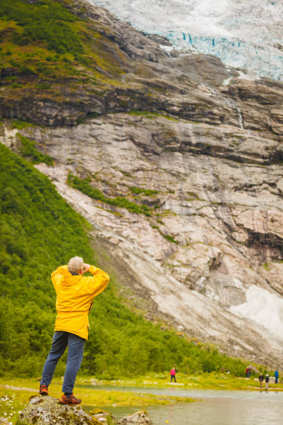 istock Tourist admiring Boyabreen Glacier in Norway 936793406