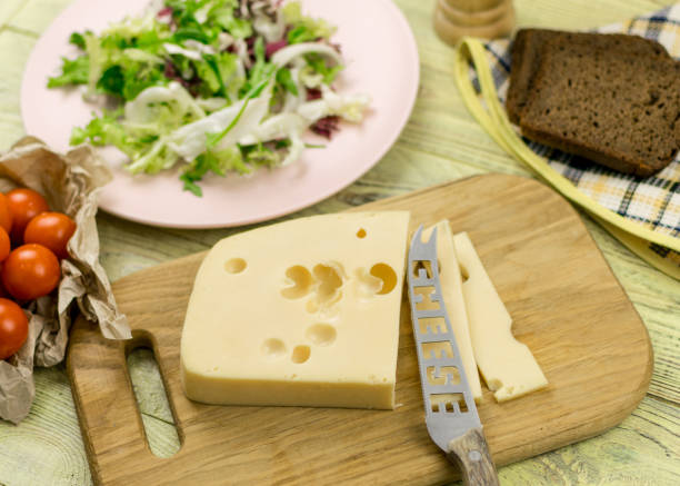 istock A piece of cheese and fresh vegetables next to a wooden surface. 936793664