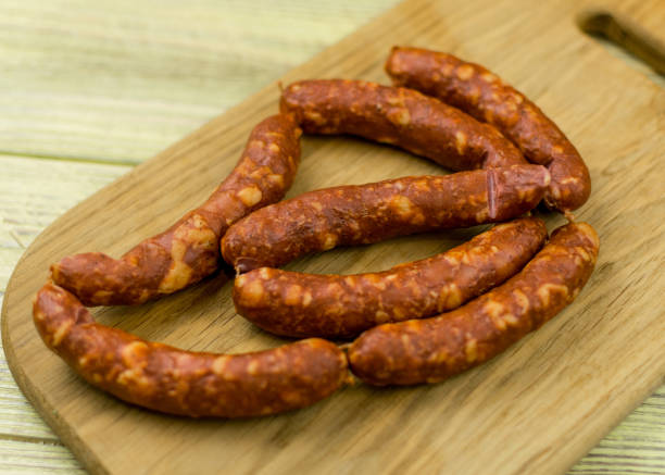 istock Smoked natural sausages   on a wooden surface. 936793682
